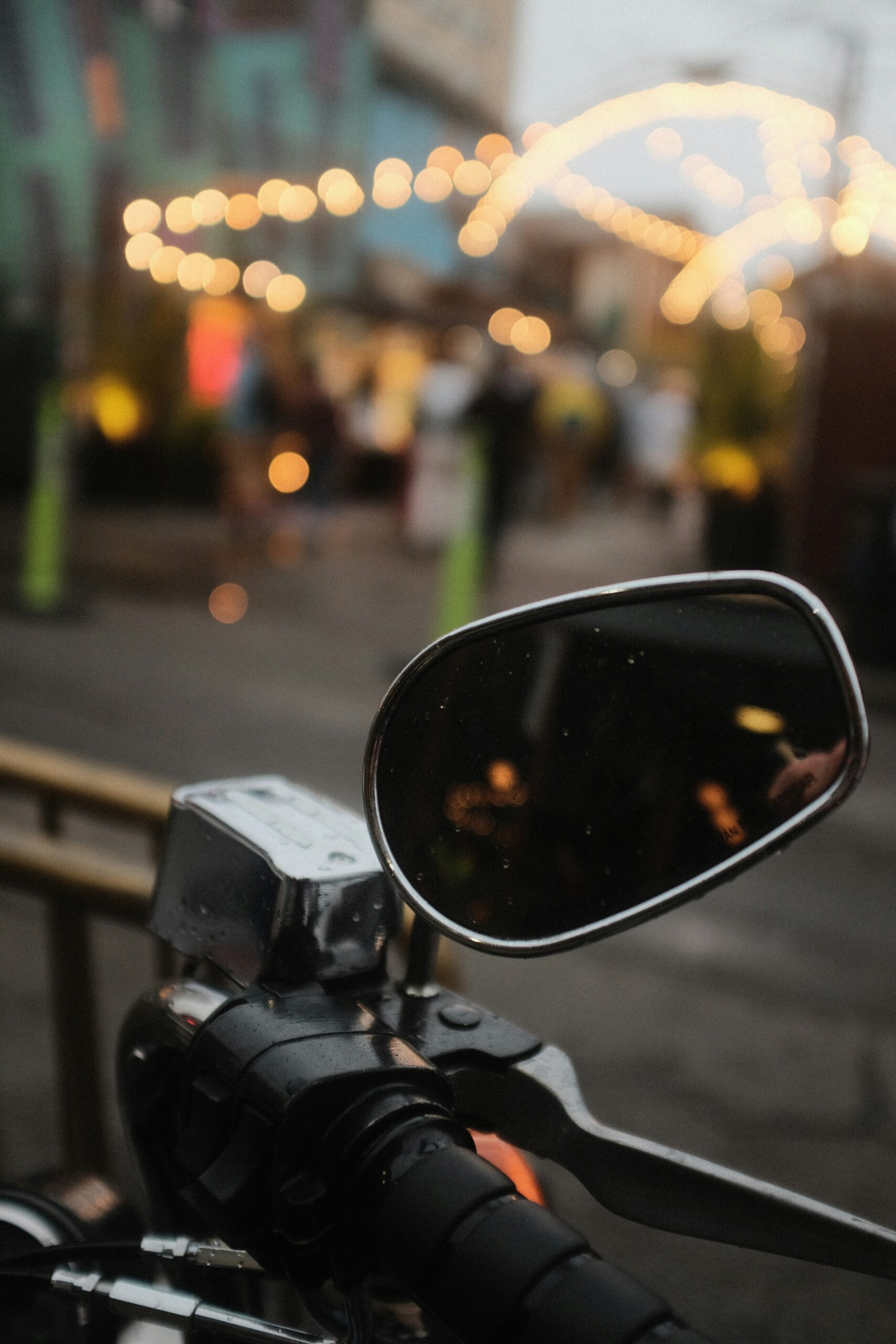 A close up of a motorcycle mirror on a street