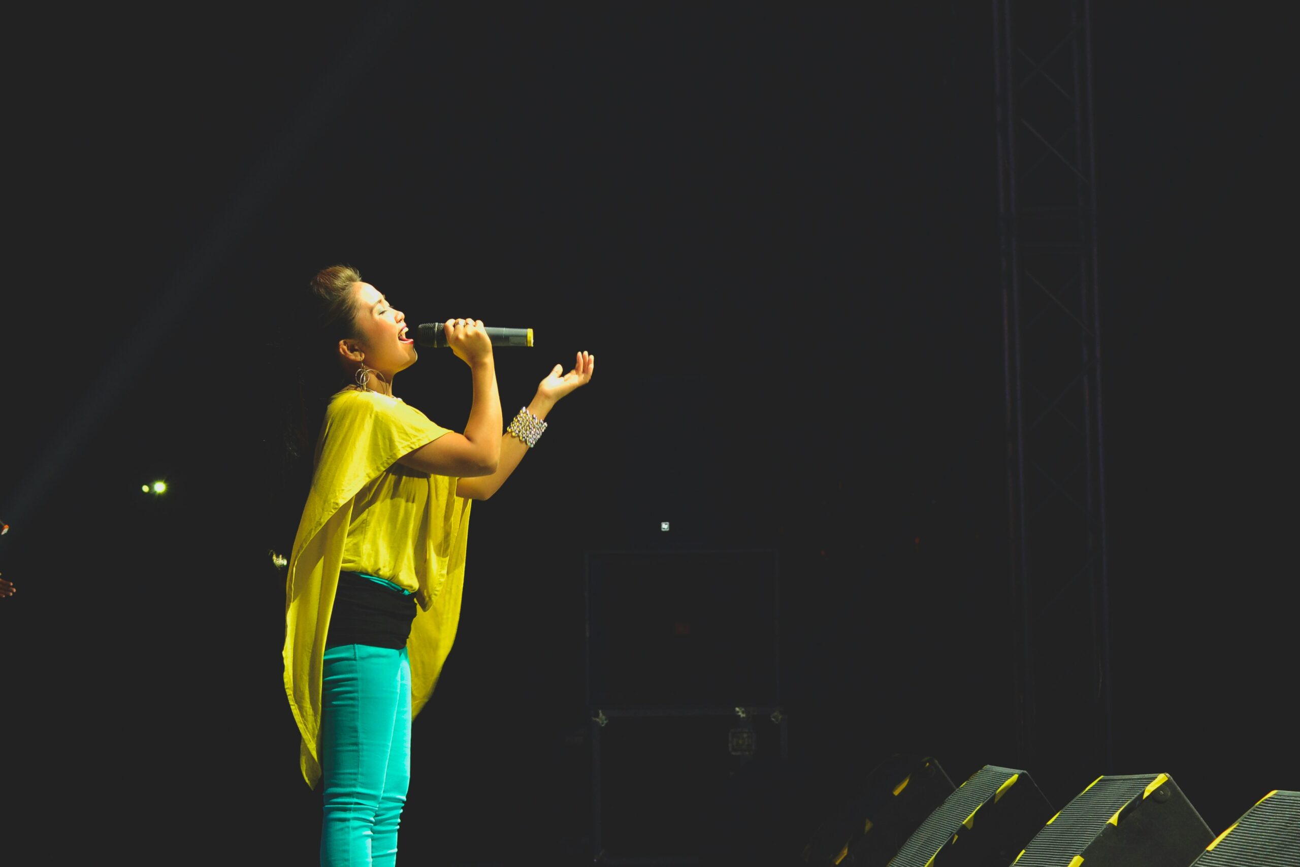 woman holding a microphone performing on stage